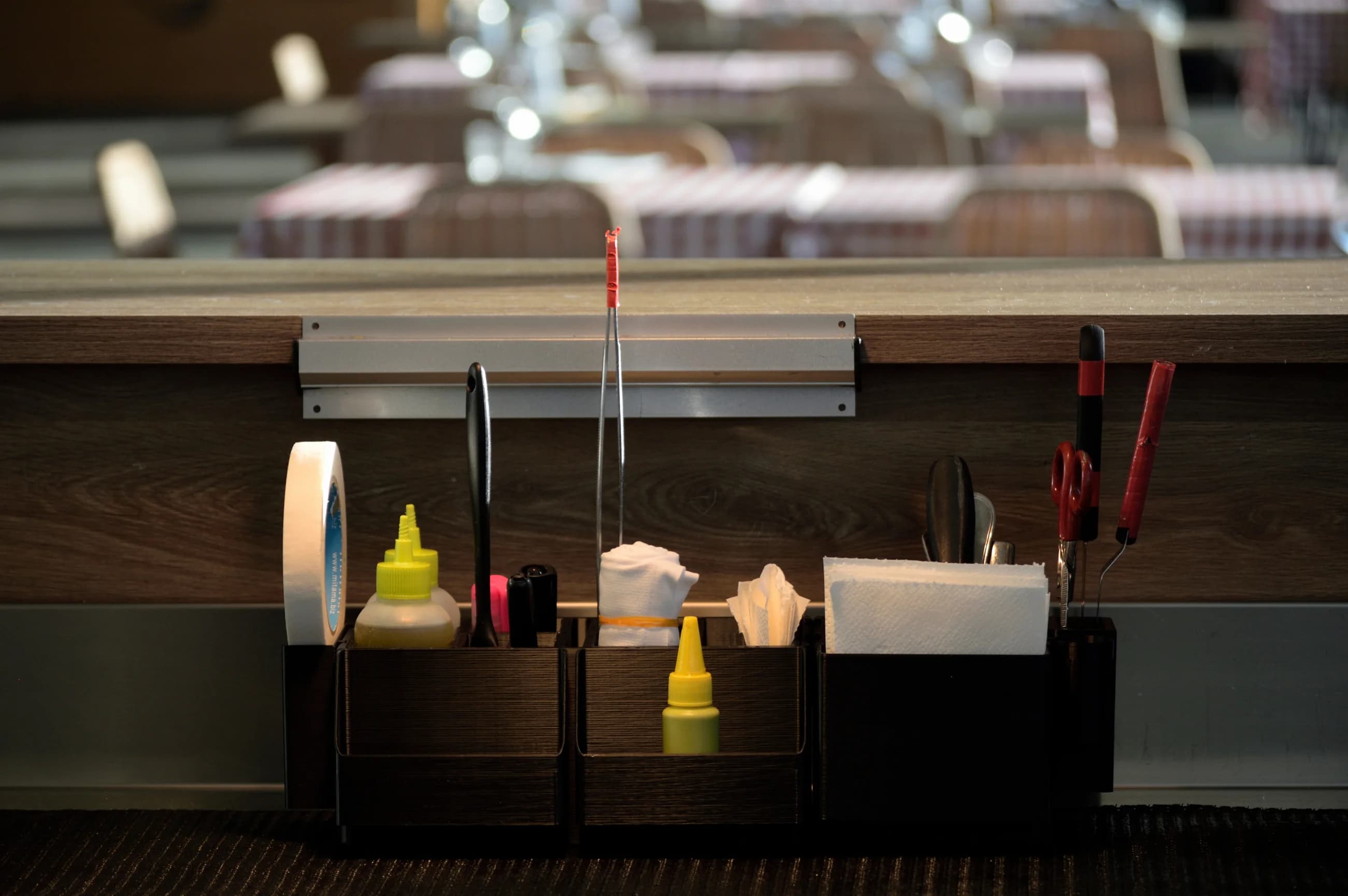 Sistema ModuloX montato sotto il banco di un locale, con pinze, squeeze bottle, tovaglioli e forbici a portata di mano